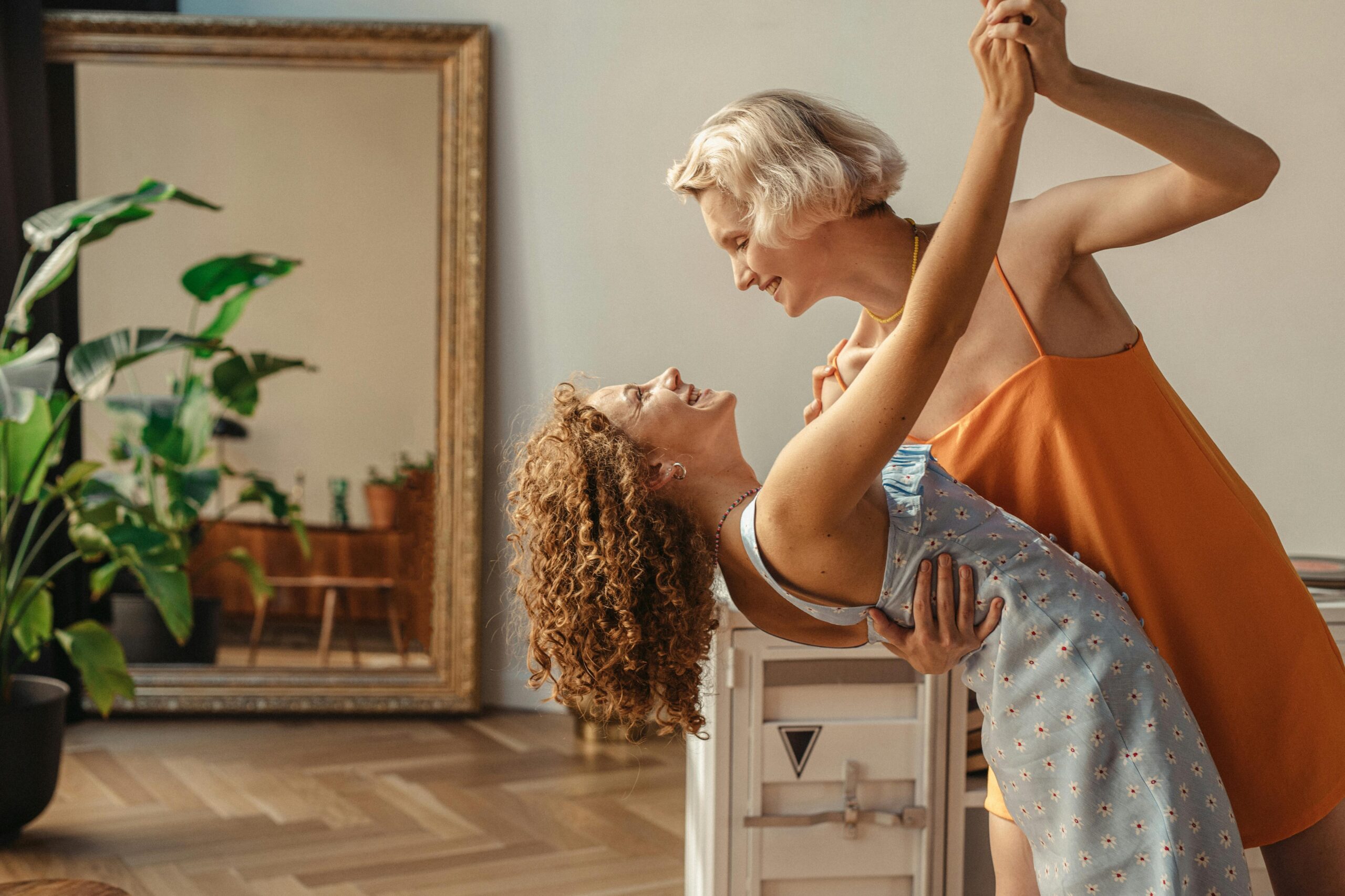 Happy couple sharing a joyful dance in a cozy indoor setting, radiating love and happiness.